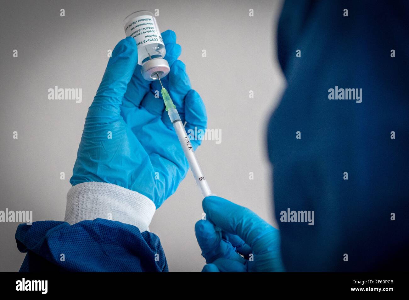 Lipsia, Germania. 23 marzo 2021. ILLUSTRAZIONE: Una donna in indumenti protettivi aspira una siringa di vaccinazione. Credit: Peter Endig/dpa-Zentralbild/ZB/dpa/Alamy Live News Foto Stock