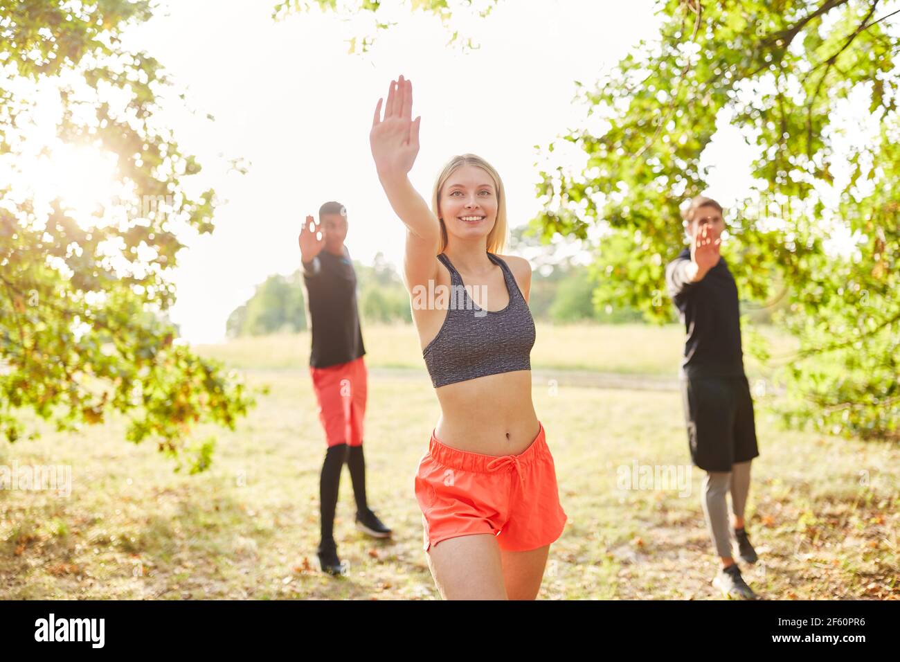 Gruppo di giovani ha divertimento facendo ginnastica di ballo dentro classe aerobica in natura Foto Stock