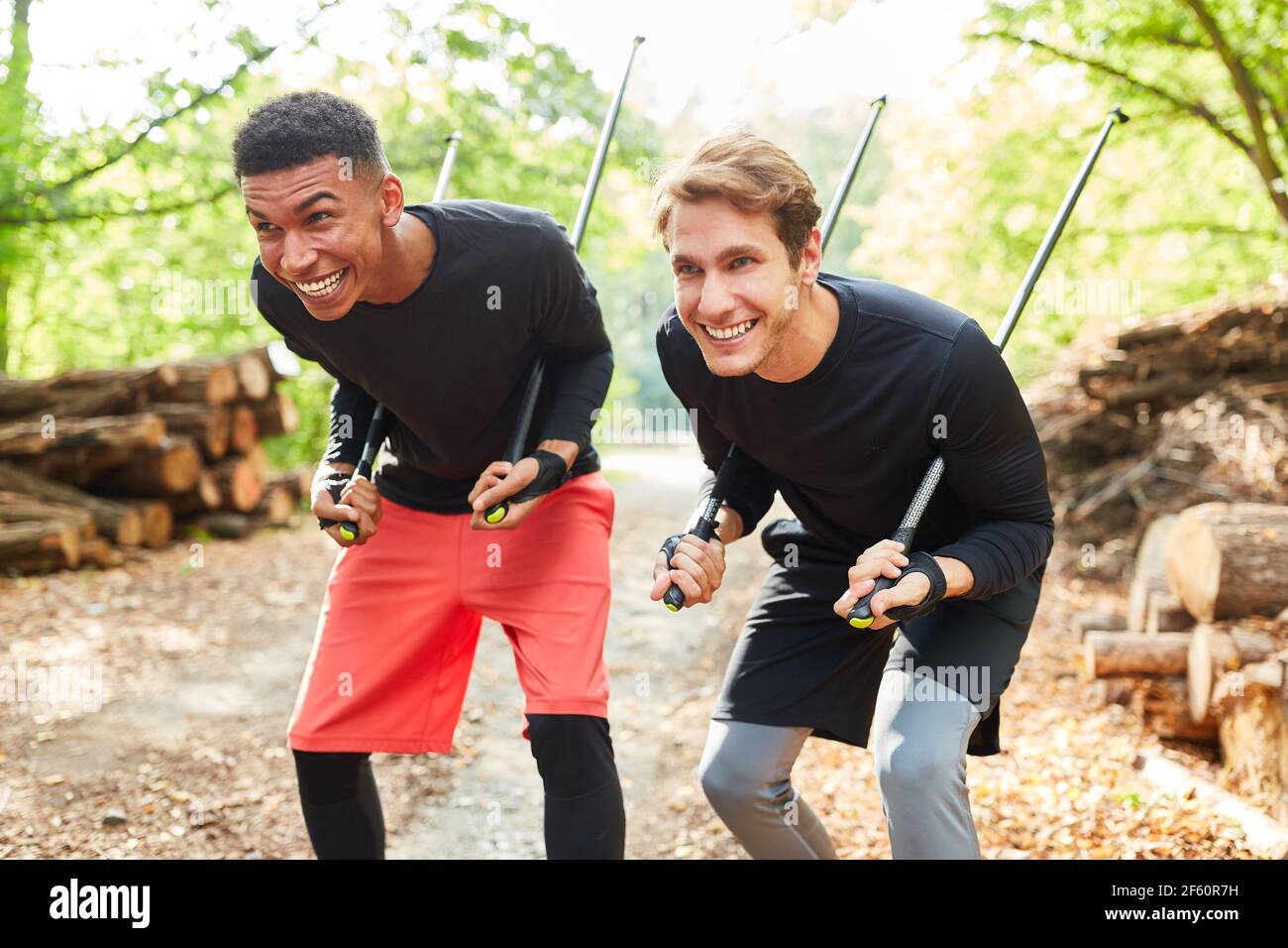 Due giovani uomini fanno male con bastoni da trekking nel Corso di nordic walking Foto Stock
