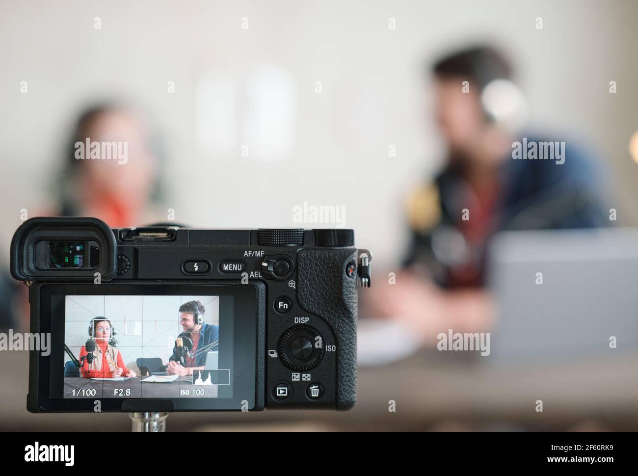 Immagine di persone in cuffia che hanno un'intervista alla radio e scattarla con la fotocamera Foto Stock