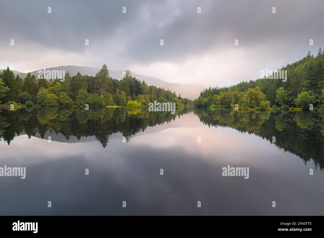 Calmo, idilliaco paesaggio montano lago riflessione su Glencoe Lochan in una serata estiva nelle Highlands scozzesi, Scozia. Foto Stock
