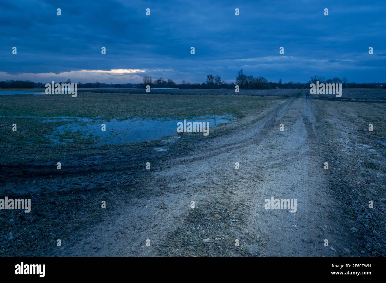Le ruote si stagliano su una strada fangosa e un cielo nuvoloso Foto Stock