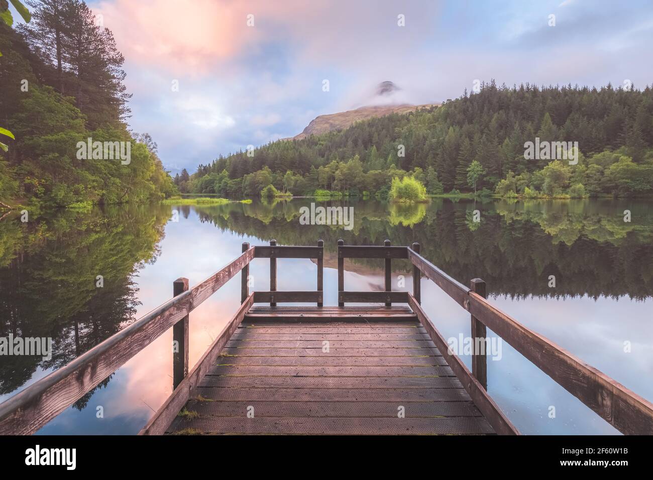 Calmo, idilliaco paesaggio montano lago riflessione su Glencoe Lochan durante un tramonto colorato o l'alba nelle Highlands scozzesi, Scozia. Foto Stock