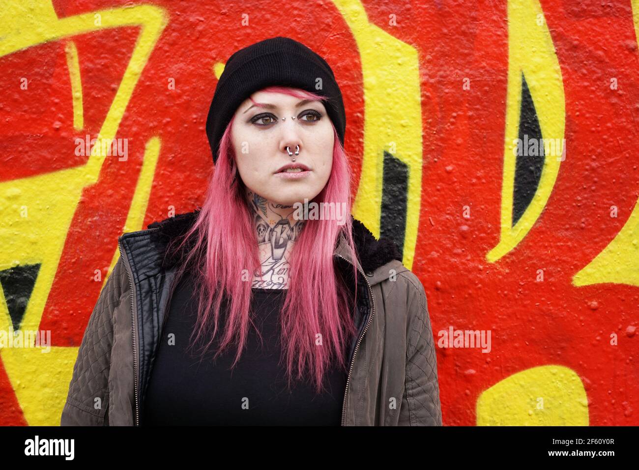 giovane donna stile e-girl di fronte al muro graffiti Foto Stock