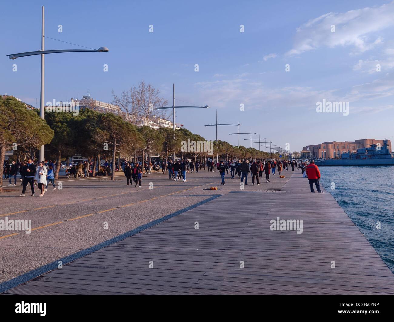 Salonicco, Grecia - Marzo 28 2021: Gran numero di persone con maschere covid-19 all'aperto. Folla non identificata con la protezione del viso cammina a breve distanza sul lungomare della città. Foto Stock