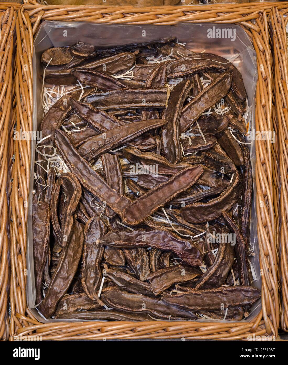 Particolare di carruba all'interno di un cesto di legno Foto Stock