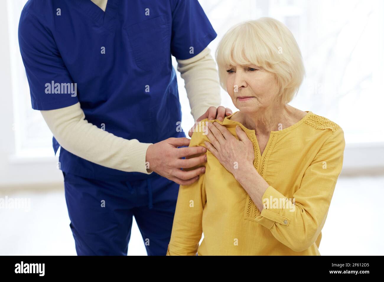 Paziente di trattamento fisioterapista. Il chiropractor tiene la mano del paziente, il trattamento dell'articolazione della spalla Foto Stock