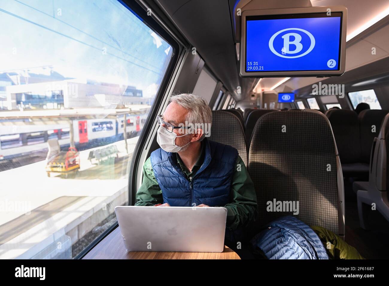 L'immagine mostra una persona seduta accanto al finestrino, in un treno, per illustrare la nuova regola secondo cui i passeggeri della ferrovia possono sedersi solo sui sedili vicino al finestrino wi Foto Stock