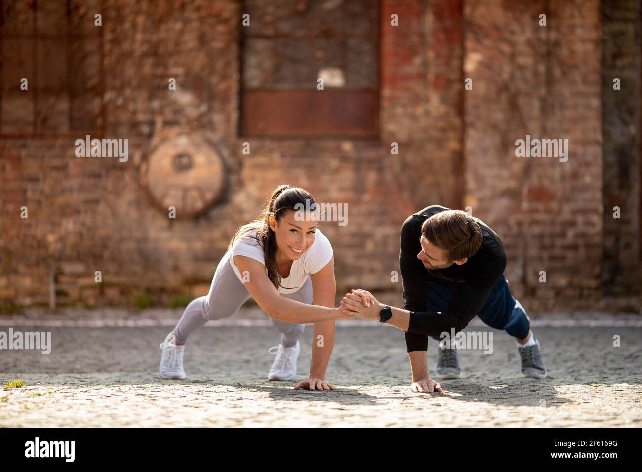 Bella giovane coppia doung un braccio pushup esercizio in ambiente urbano Foto Stock