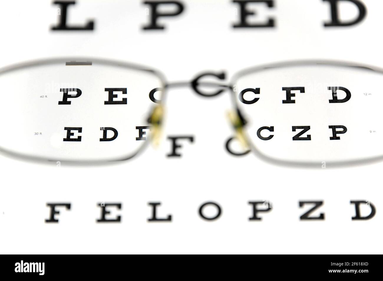 Occhiali e snellen eye chart. Il grafico del test oculare viene mostrato sfocato sullo sfondo. Test visivo di Acuity (grafico Snellen). Foto Stock