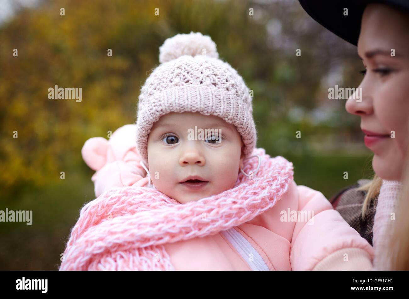 Bella bambina con madre all'aperto. Famiglia all'aperto. Adorabile bambina in abiti caldi nel parco autunnale in giornata di sole. Bella bambina con la mo Foto Stock