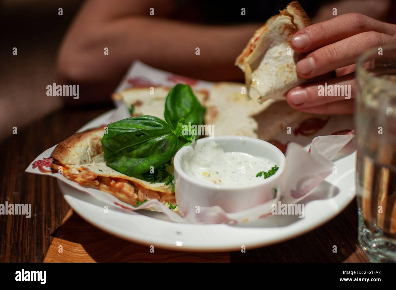 Uomo che mangia deliziosa quesadilla al ristorante Foto Stock