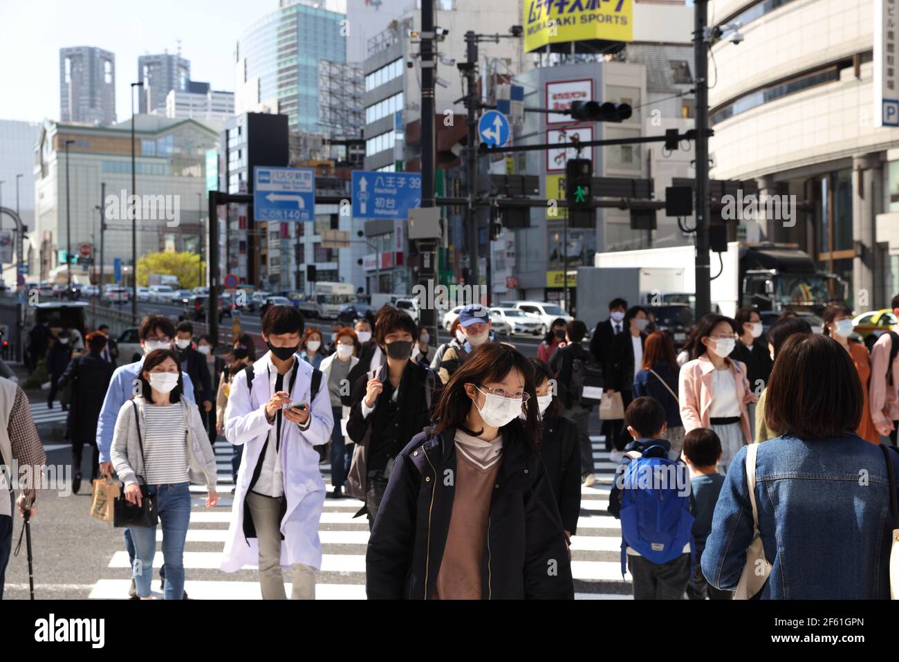 Tokyo, Giappone. 24 Marzo 2021. I pedoni che indossano maschere facciali come misura preventiva contro Covid-19 attraversano una strada trafficata a Shinjuku, Tokyo. Credit: SOPA Images Limited/Alamy Live News Foto Stock