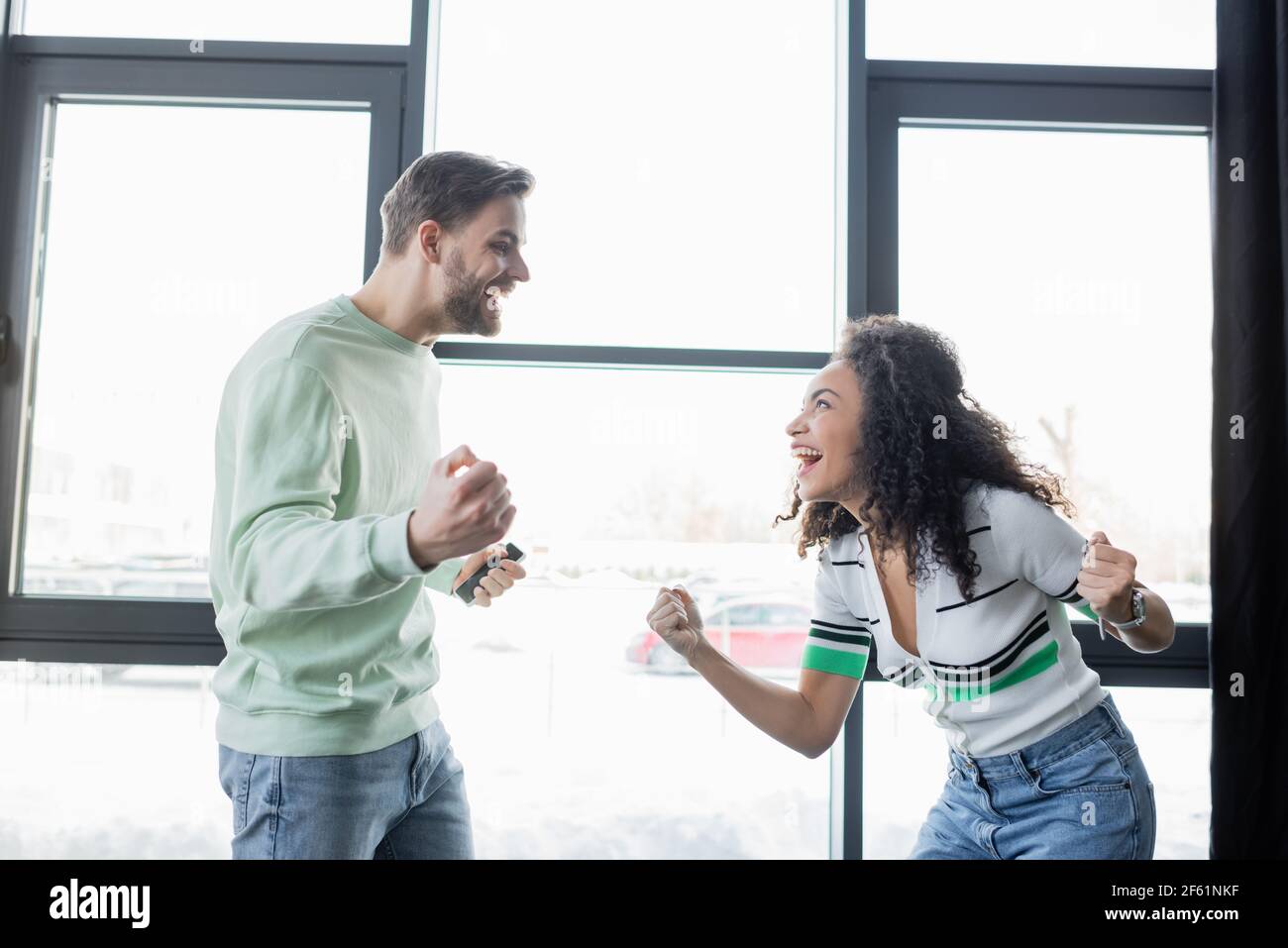i partner commerciali sono entusiasti di guardare l'un l'altro mentre mostrano il trionfo gesto in ufficio Foto Stock