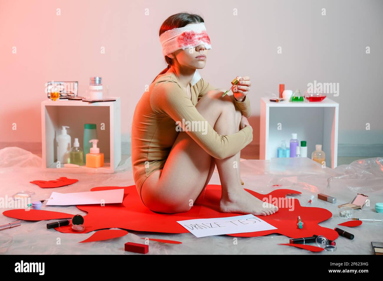 Giovane donna con cosmetici in laboratorio. Arrestare il test degli animali Foto Stock