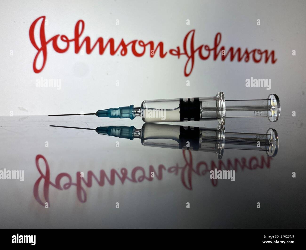 Johnson & Johnson Covid19 vaccino Coronavirus - siringa con Johnson E il logo Johnson sullo sfondo sfocato con riflessione Foto Stock