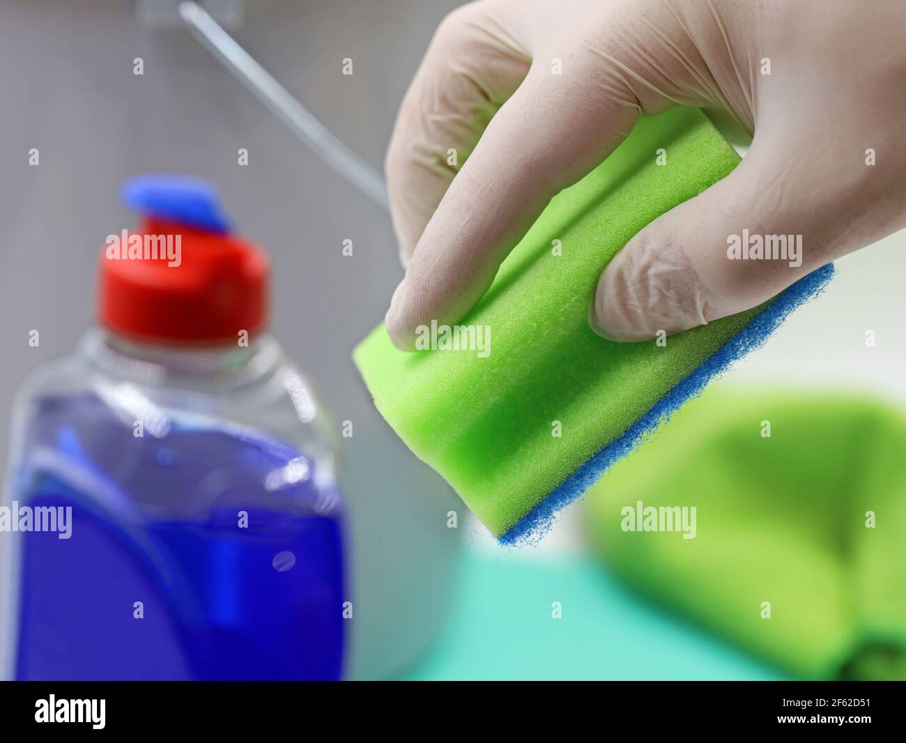 i guanti a mano trattengono la spugna sugli utensili domestici, concetto di fondo della pulizia domestica, primo piano Foto Stock