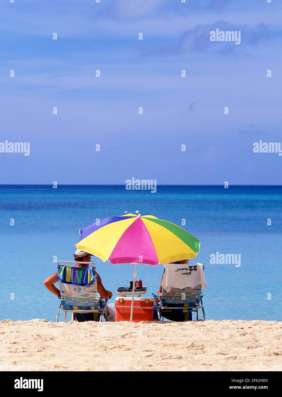 Coppia anziana che siede sulla spiaggia, Seven Mile Beach, West Bay, Grand Cayman, Isole Cayman, Grandi Antille, Caraibi Foto Stock
