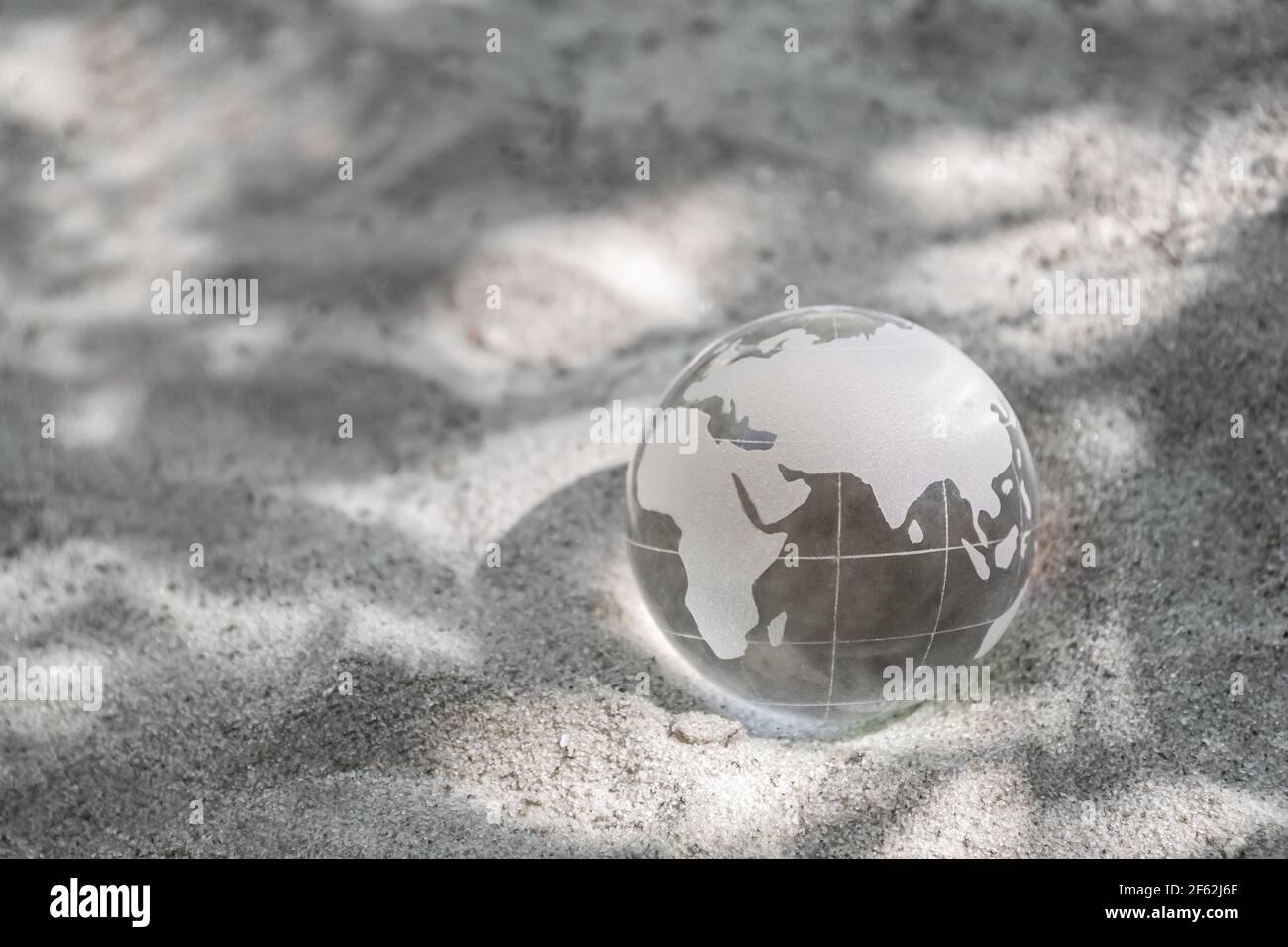 Pianeta di vetro sulla sabbia. Concetto di cambiamento climatico, protezione ambientale. Giorno della Terra Foto Stock