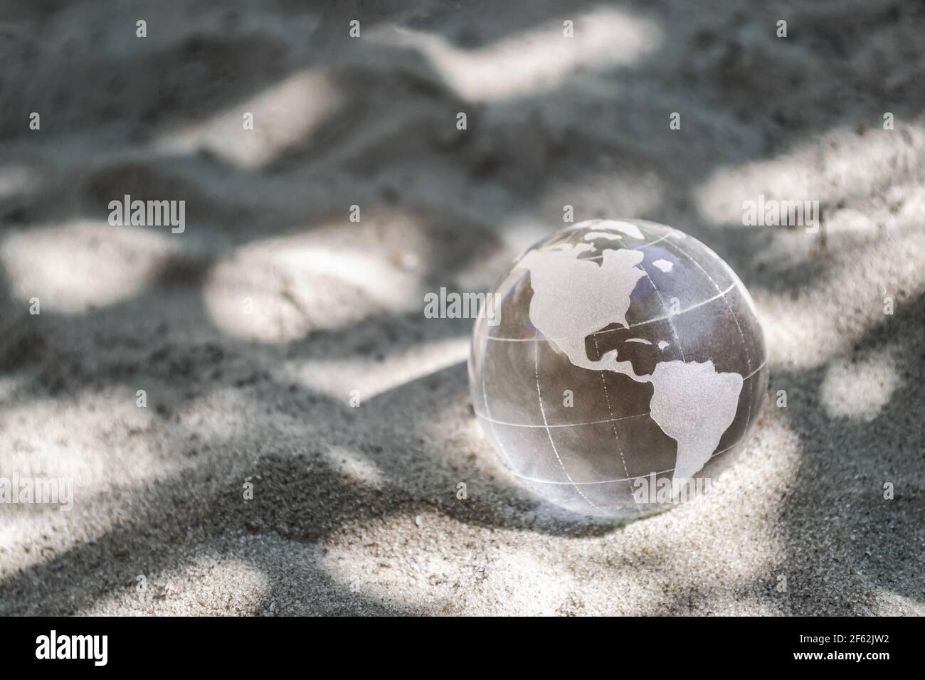 Pianeta di vetro sulla sabbia. Concetto di cambiamento climatico, protezione ambientale. Giorno della Terra Foto Stock