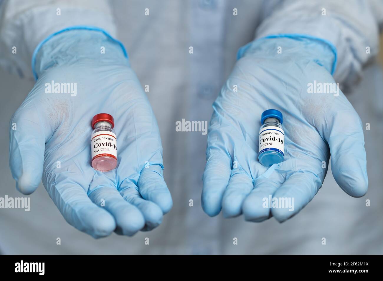 Il medico tiene in mano due diversi flaconcini di vaccino per il coronavirus coviale. Foto Stock