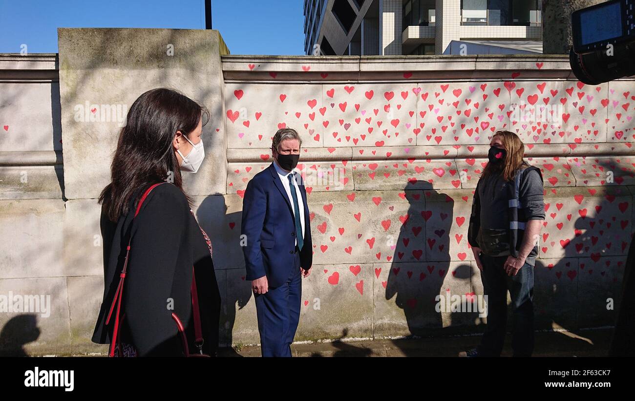 Londra, Regno Unito. 29 marzo 2021. La famiglia e gli amici in lutto vengono visitati da Keir Starmer mentre dipingono i cuori sulla parete commemorativa del Covid. Foto Stock