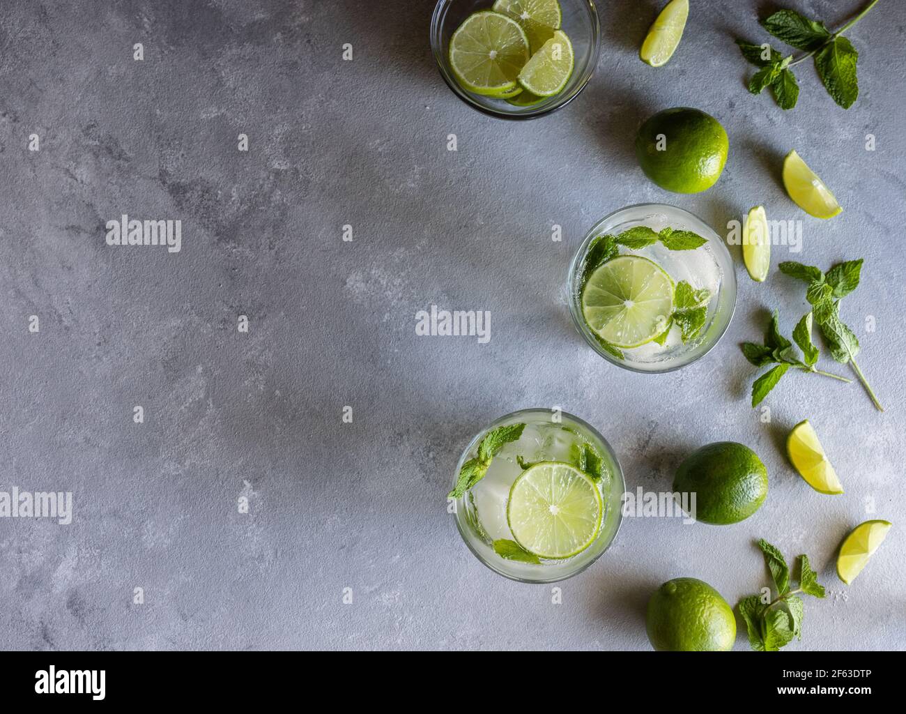 Vista dall'alto dei cocktail Mojito con Limes e Mint on Superficie grigia Foto Stock