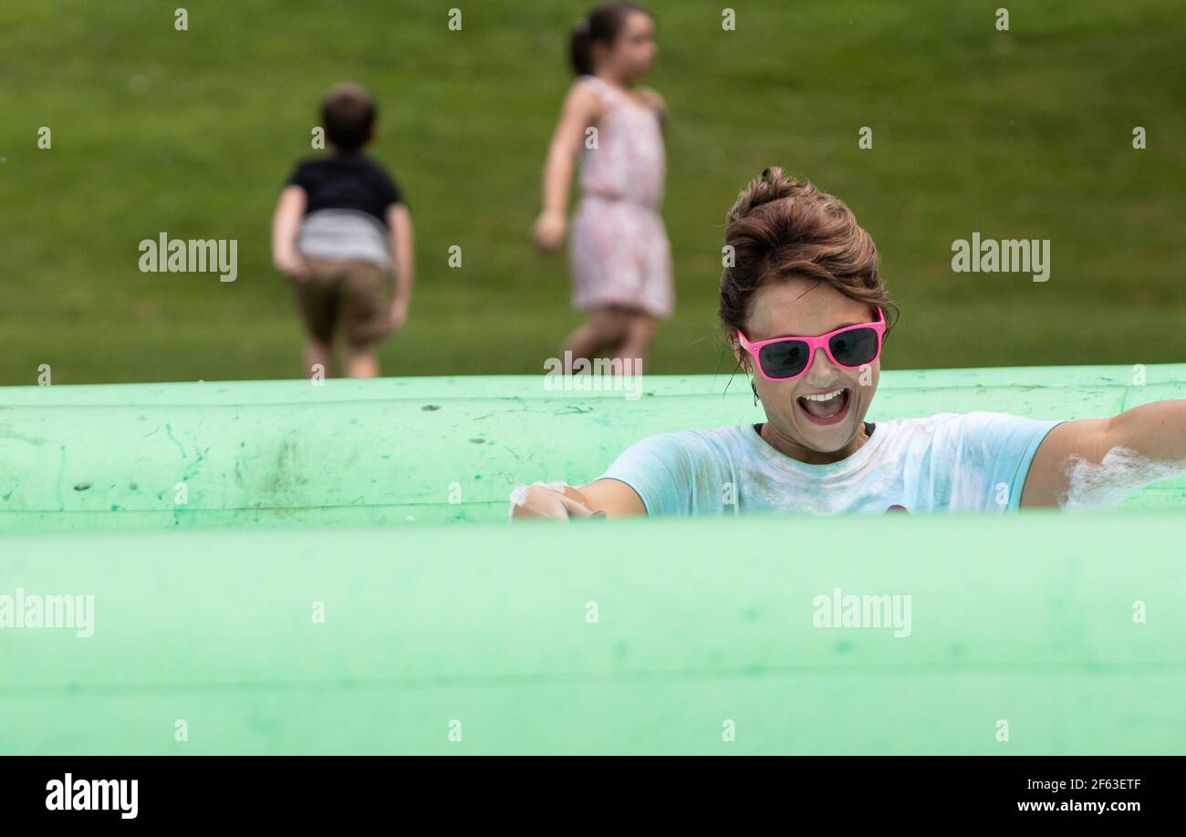 Donna in occhiali da sole godendo di una carità raccolta fondi schiuma Bubble Rush evento Foto Stock