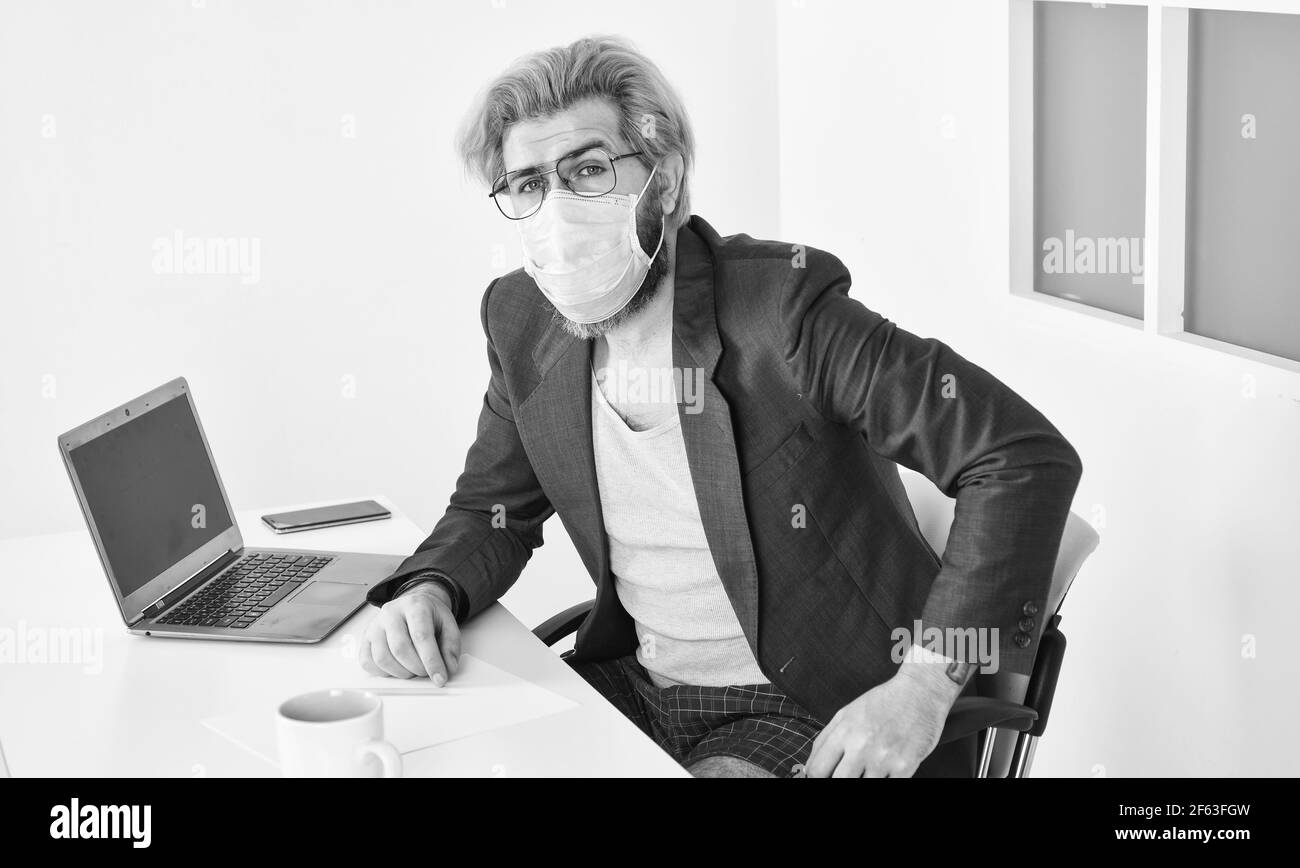 Evitare il contatto con altre persone. Rimani a casa. Uomo indossare maschera medica lavoro con computer portatile. Lavorare da casa. Online. Tattica di risposta top autoisolamento per Foto Stock
