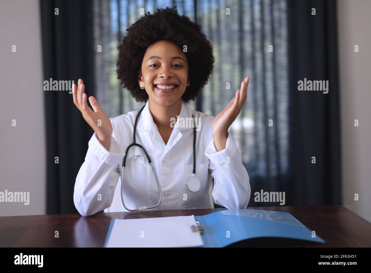 African american femmina medico seduta facendo video chiamata consultazione Foto Stock