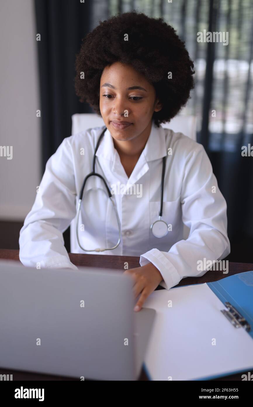 African american femmina medico seduta facendo video chiamata consultazione Foto Stock