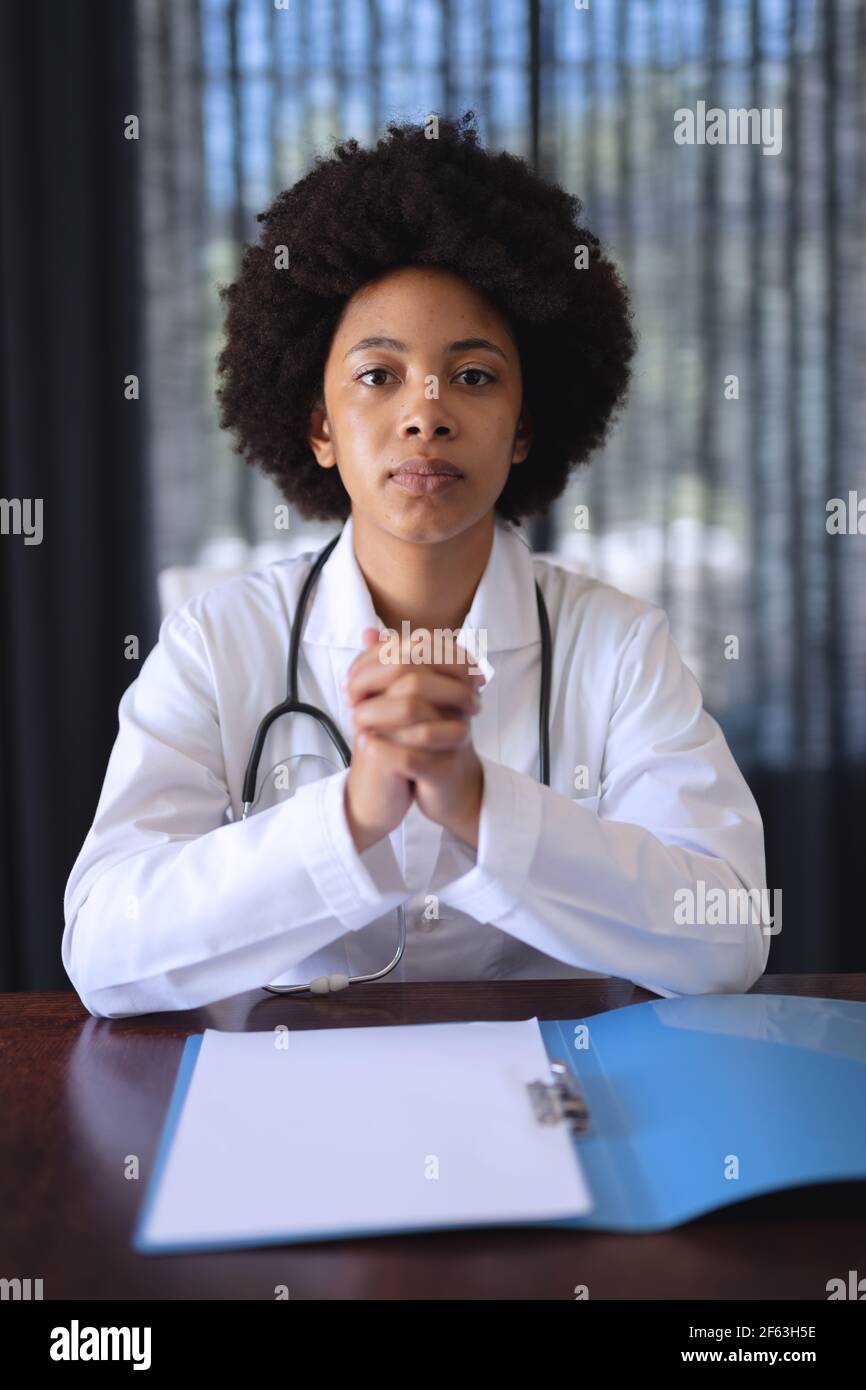 African american femmina medico seduta facendo video chiamata consultazione Foto Stock