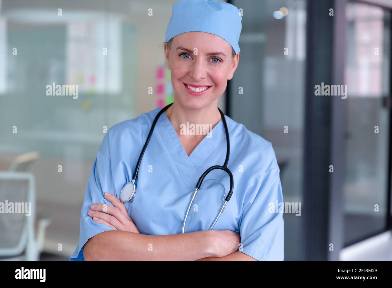 Ritratto di sorridente dottoressa caucasica con scrub e stetoscopio Foto Stock