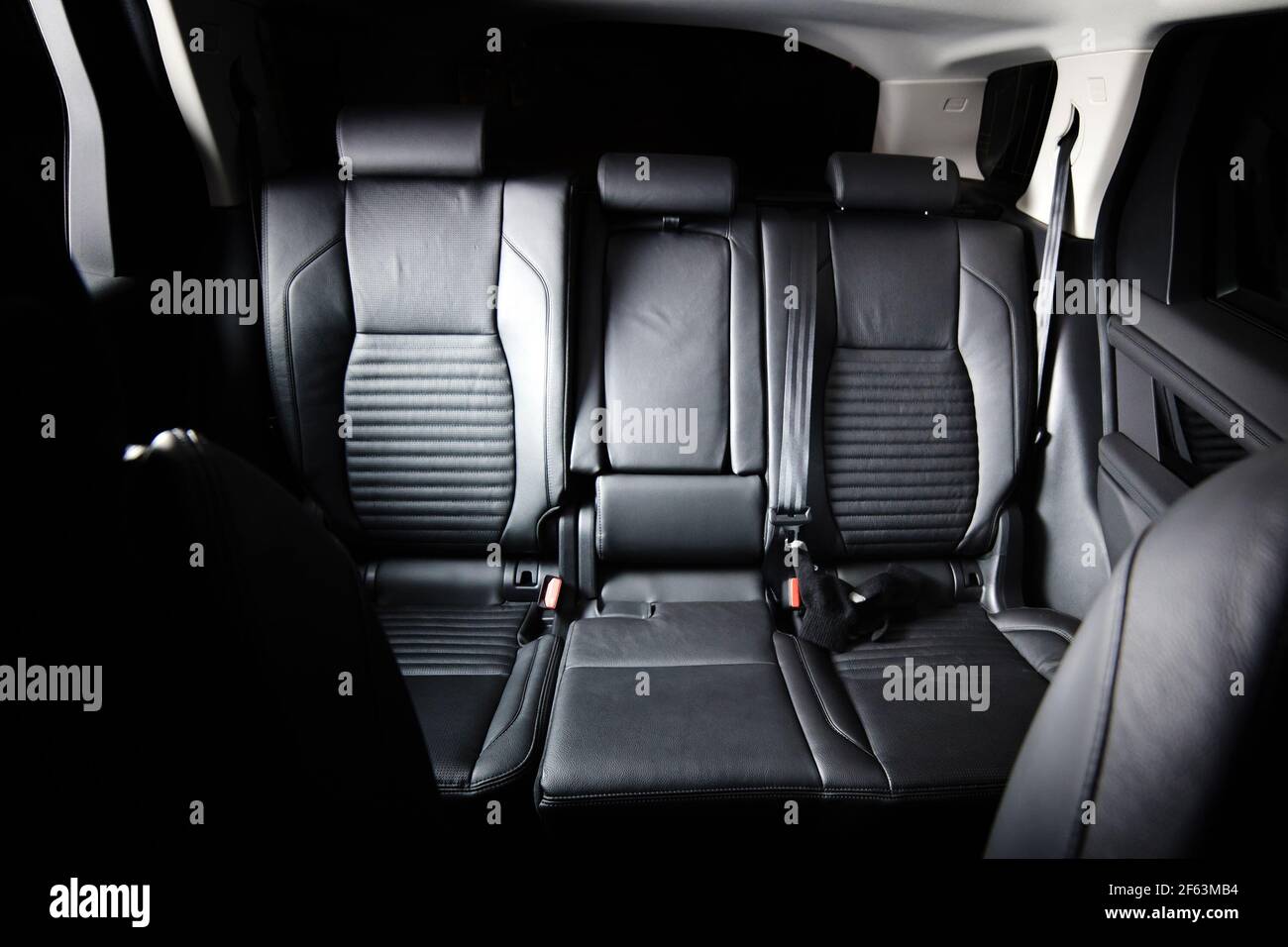 Interni di lusso scuro per auto nuove. Sedili posteriori per passeggeri in auto moderna. Sedili posteriori e cinture di sicurezza in pelle Foto Stock