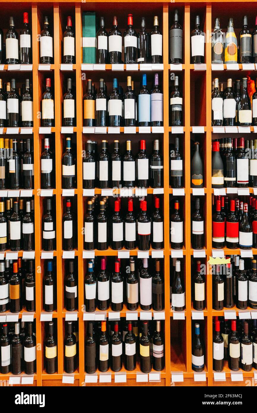 Vetrina con bottiglie di vino presso il negozio di vini. Parete con bevande  alcoliche bottiglie di vino su scaffali Foto stock - Alamy