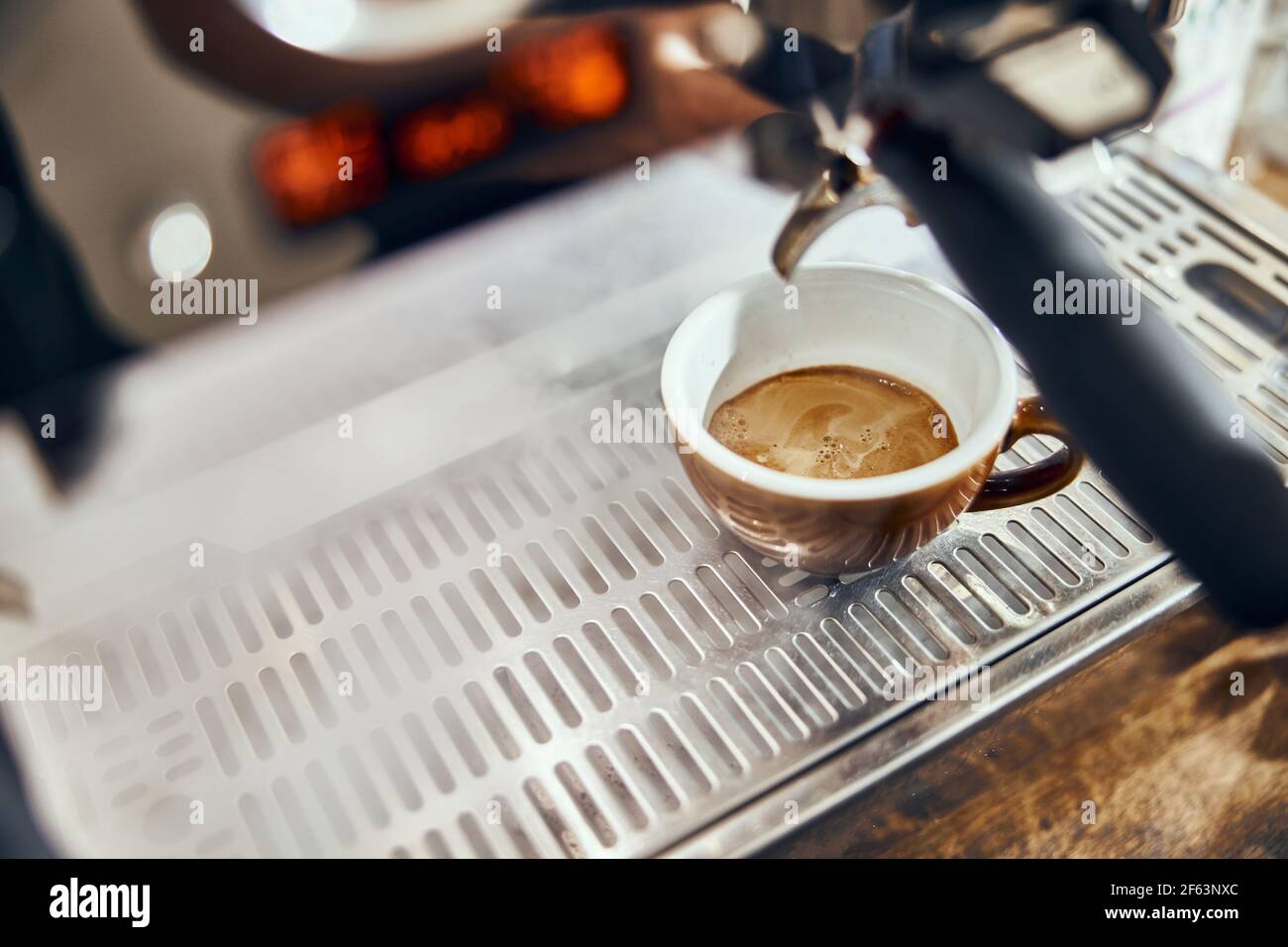 Primo piano di espresso versato dalla macchina da caffè. Caffè professionale. Foto Stock