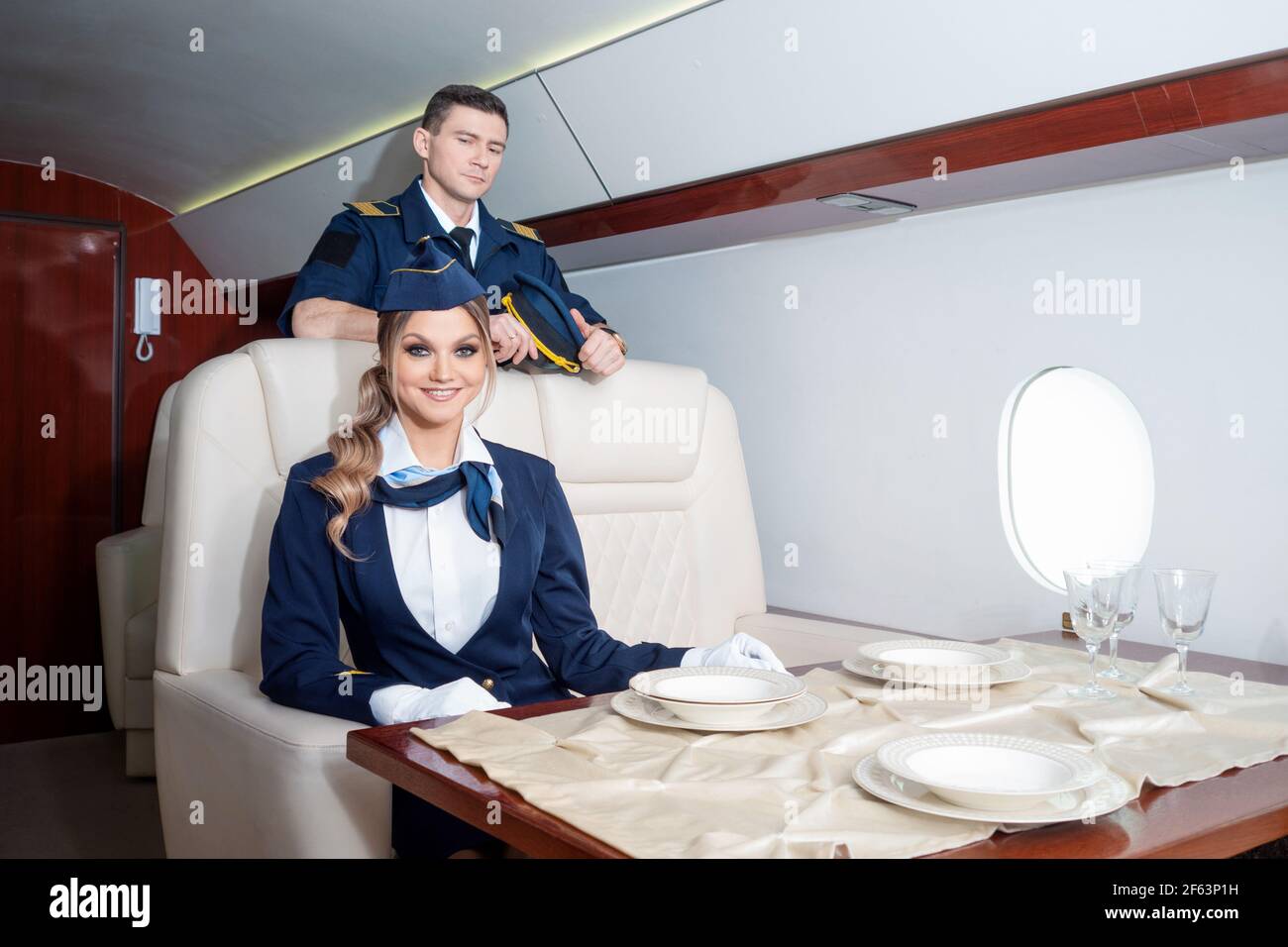 Assistenti di volo e piloti, equipaggio di aeromobili benvenuti a bordo, business class o jet privati. Foto Stock