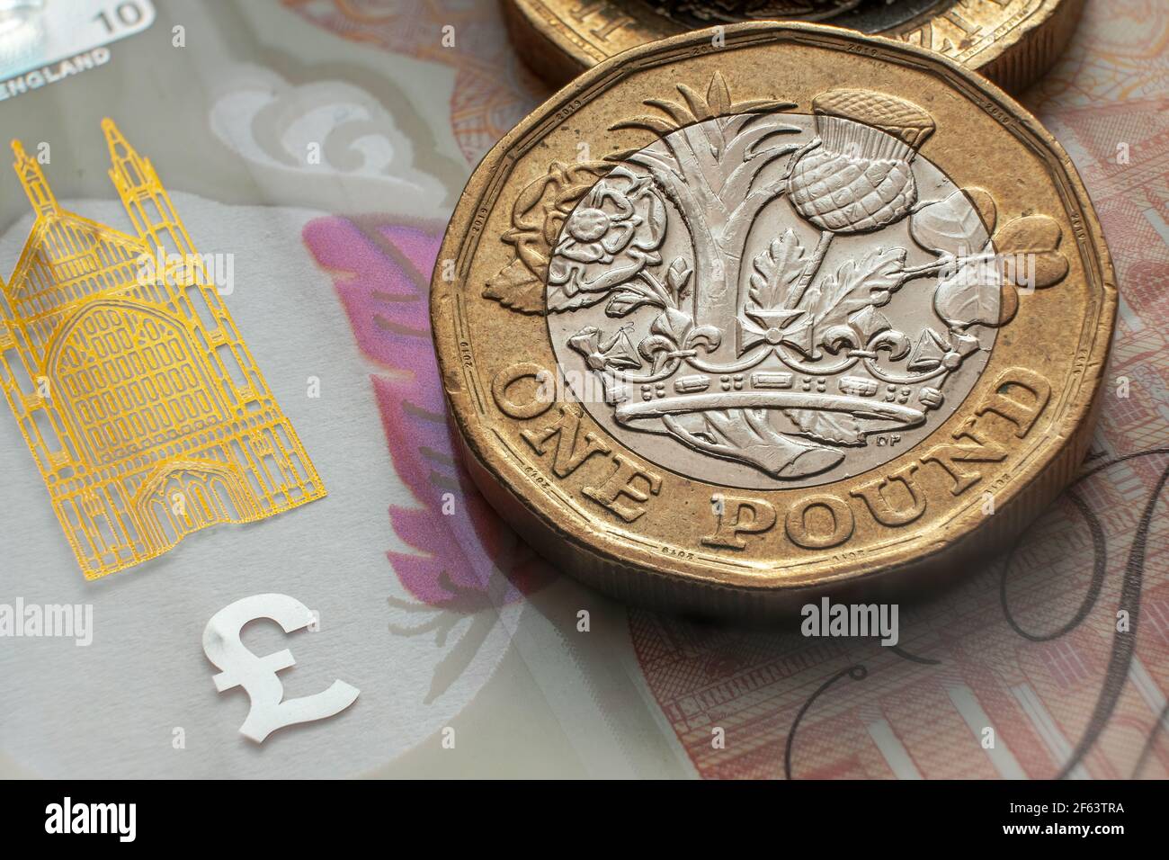 Monete inglesi da una libbra poste su una banconota da 10 libbre. Concetto. Messa a fuoco selettiva. Macro. Foto Stock