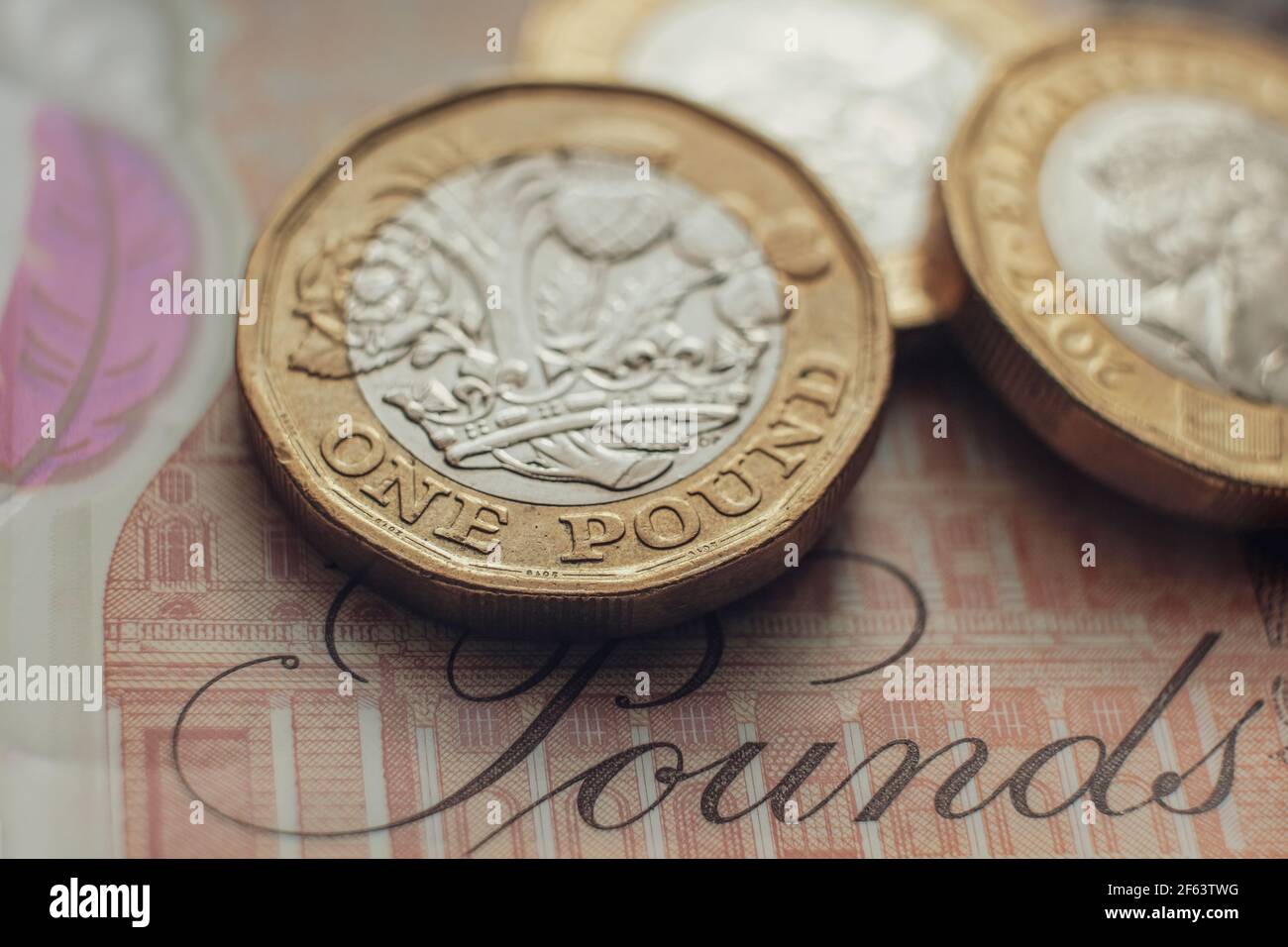 Monete inglesi da una libbra poste su una banconota da 10 libbre. Concetto. Messa a fuoco selettiva. Macro. Foto Stock