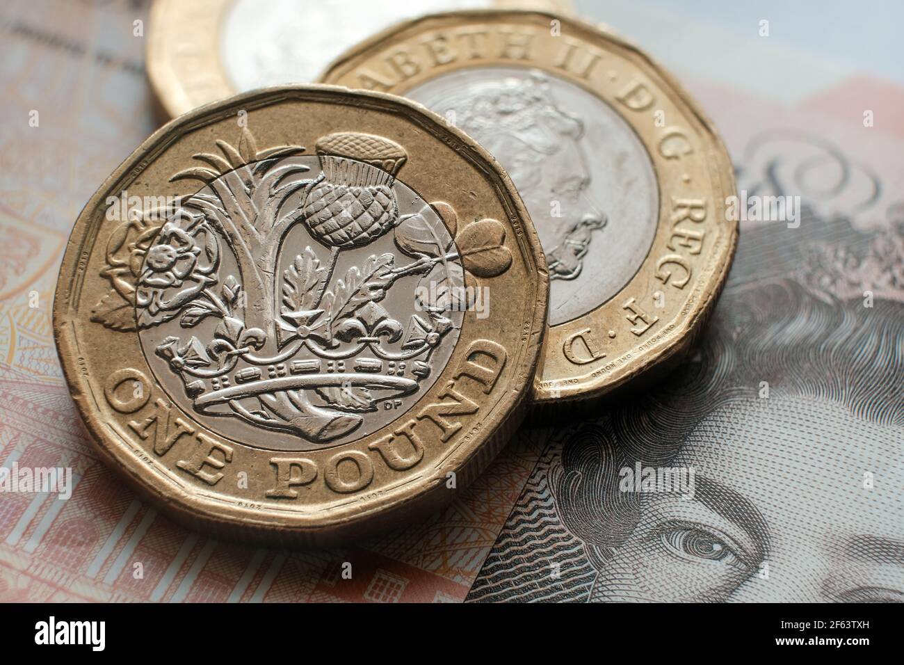 Monete inglesi da una libbra poste su una banconota da 10 libbre. Concetto. Messa a fuoco selettiva. Macro. Foto Stock
