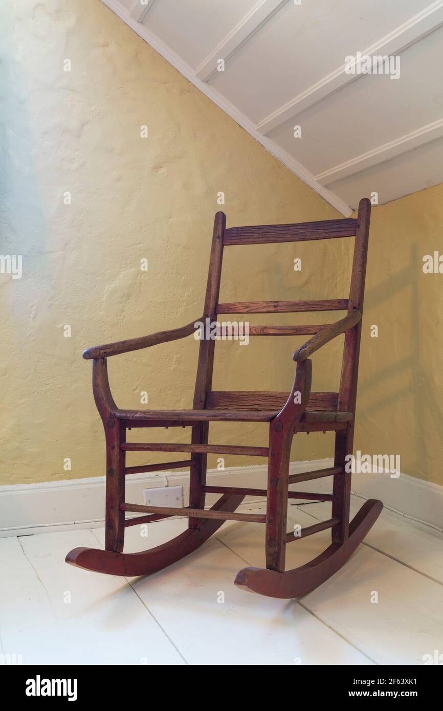 Antica poltrona dondolo con sedile in legno massello nella camera