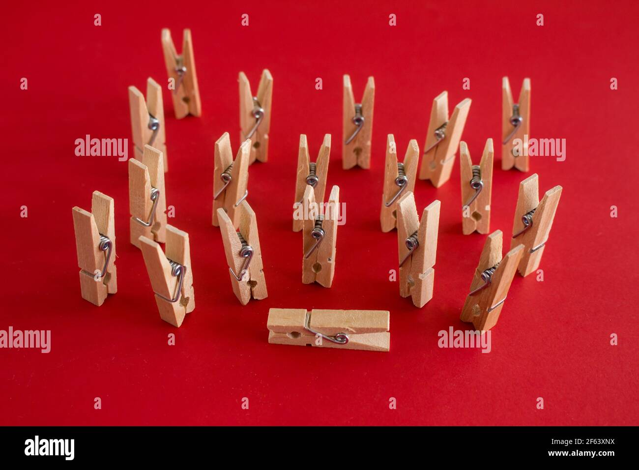 Rappresentazione di esseri umani con clothespins. Concetto di malattia o morte e ultimo Arrivederci. Messa a fuoco selettiva su sfondo rosso. Foto Stock