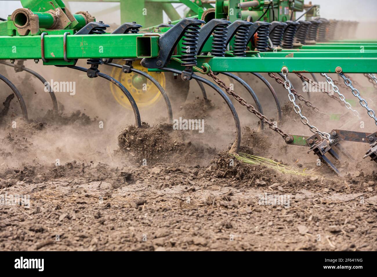 Primo piano del terreno di lavoro dei coltivatori di campo in campo agricolo. Concetto di stagione di piantatura, dissodamento e manutenzione di attrezzatura Foto Stock