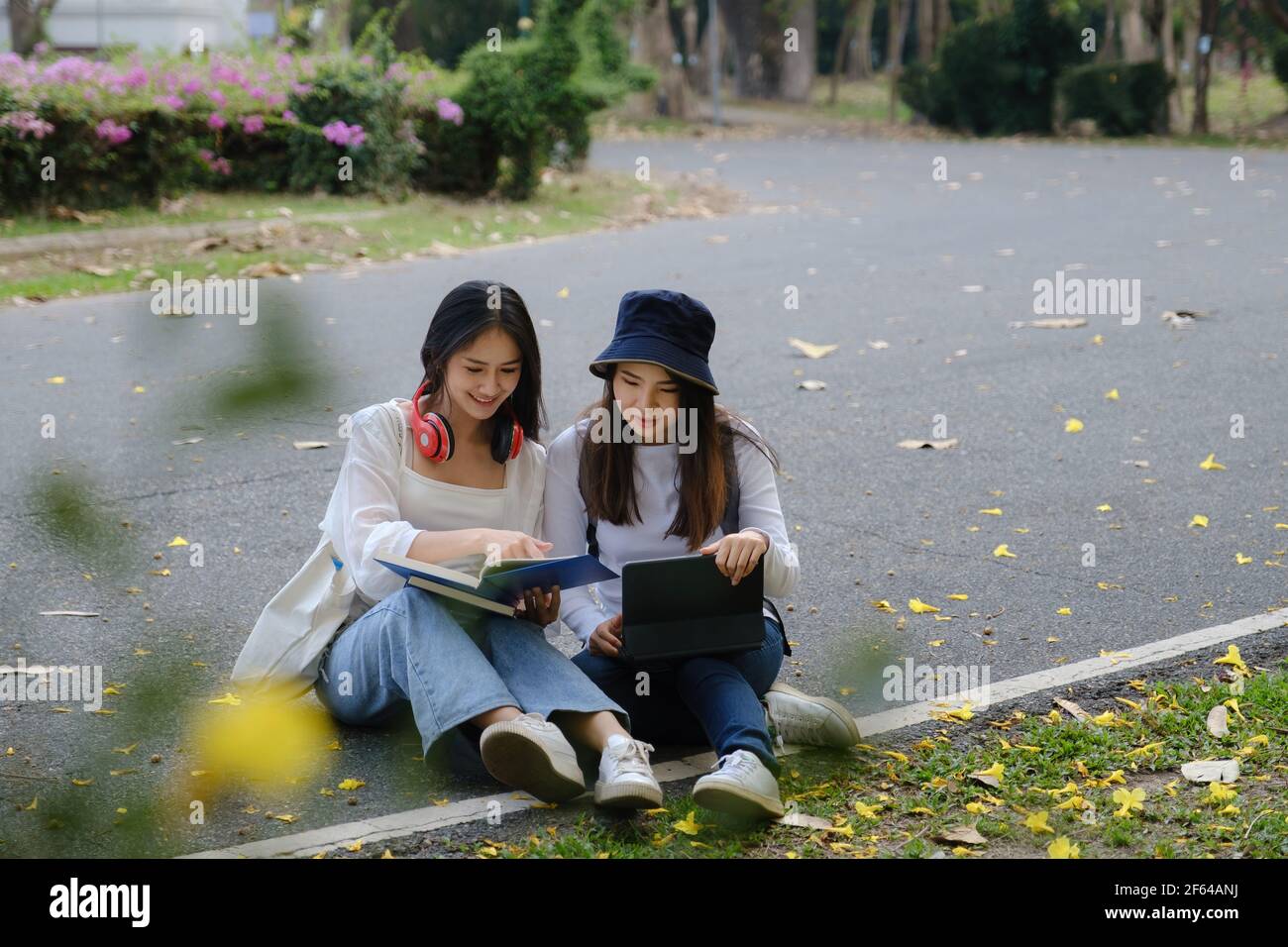 Due studenti si trovano all'università durante la lettura di un libro e della comunicazione. Studio, istruzione, università, università, concetto di laurea. Foto Stock