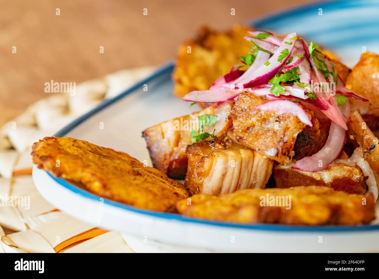 un piatto di piantana fritta servito con manzo grattugiato a gocce con salsa di cipolla e lime macro Foto Stock
