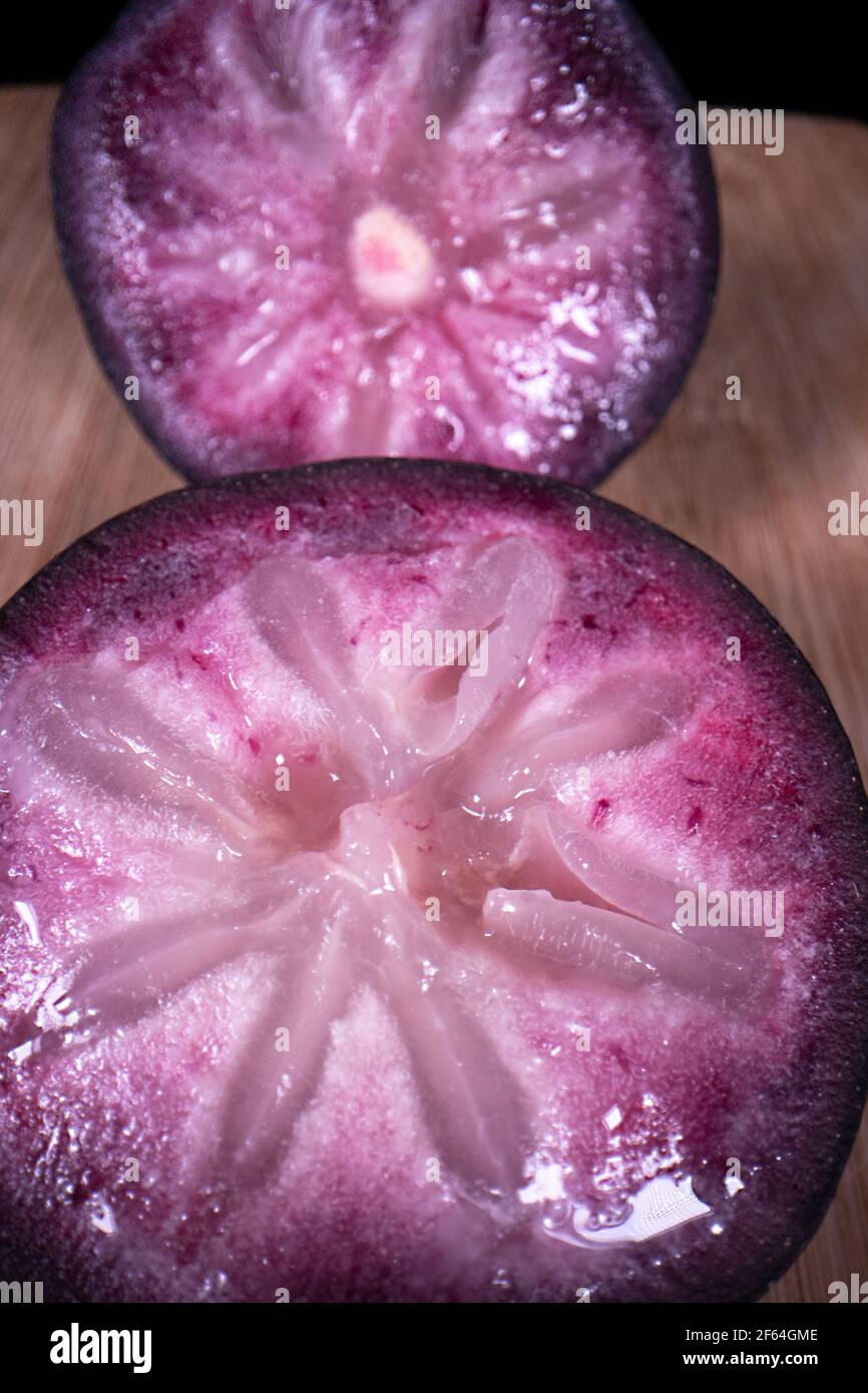 Una mela stella matura che mostra la frutta colorata tagliata a metà, una popolare frutta di stagione nelle Filippine. Foto Stock