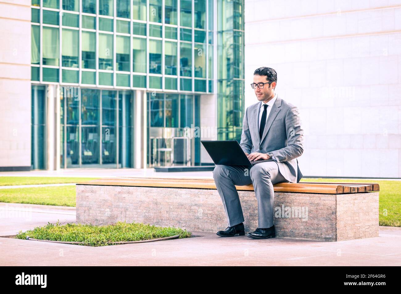 Giovane uomo d'affari hipster seduto con un computer portatile nel business center - concetto moderno di connessione wifi Foto Stock