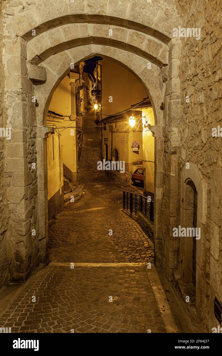Vista notturna di una delle porte di accesso al borgo medievale di Pettorano sul Gizio, illuminato dalla luce artificiale. Pettorano, Abruzzo Foto Stock
