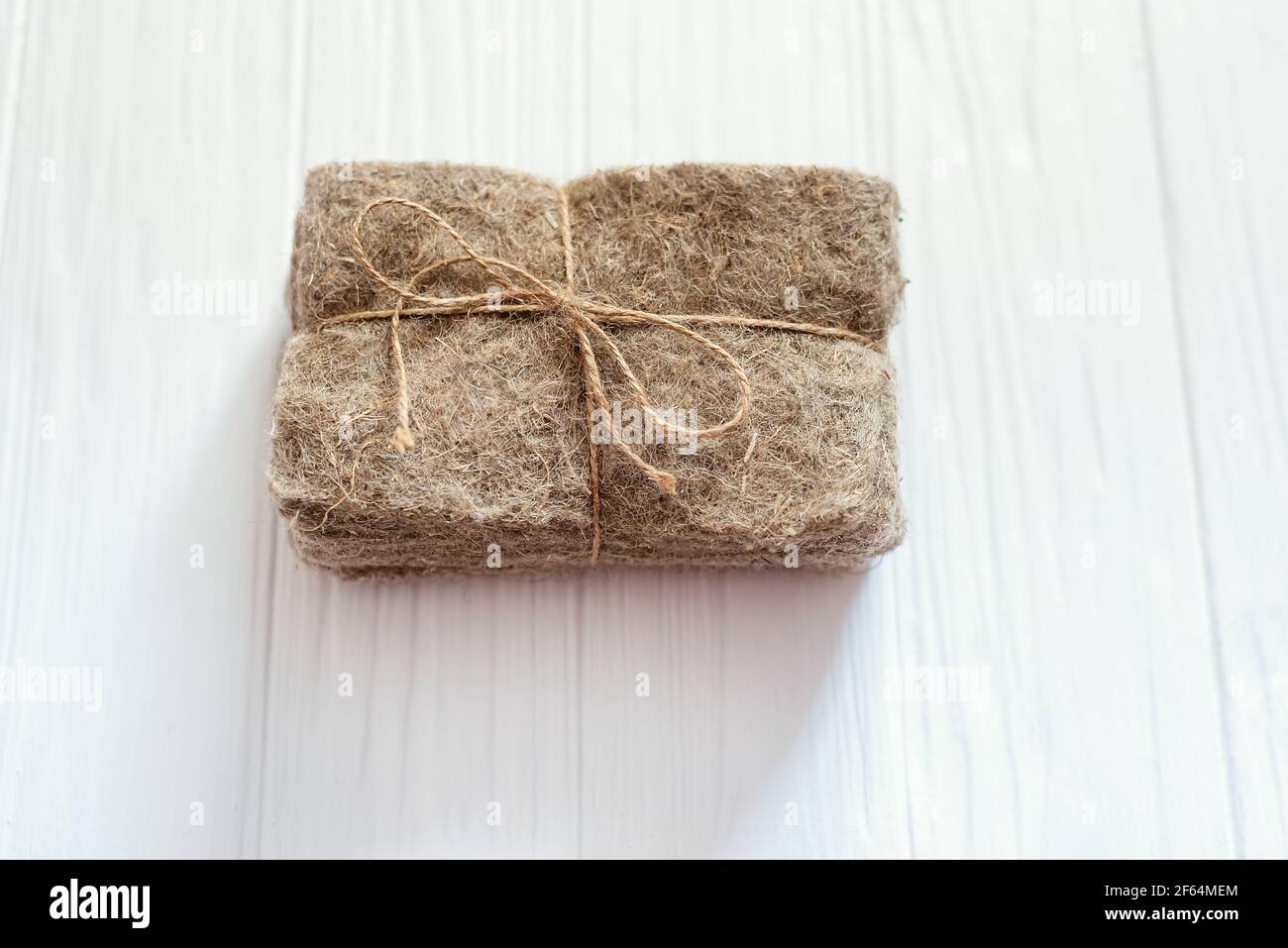 Confezioni di tappetini in lino su sfondo bianco di legno. Micrgreens che piantano business. Base naturale per piante crescenti. Vitamine dalla natura. Vegan e. Foto Stock