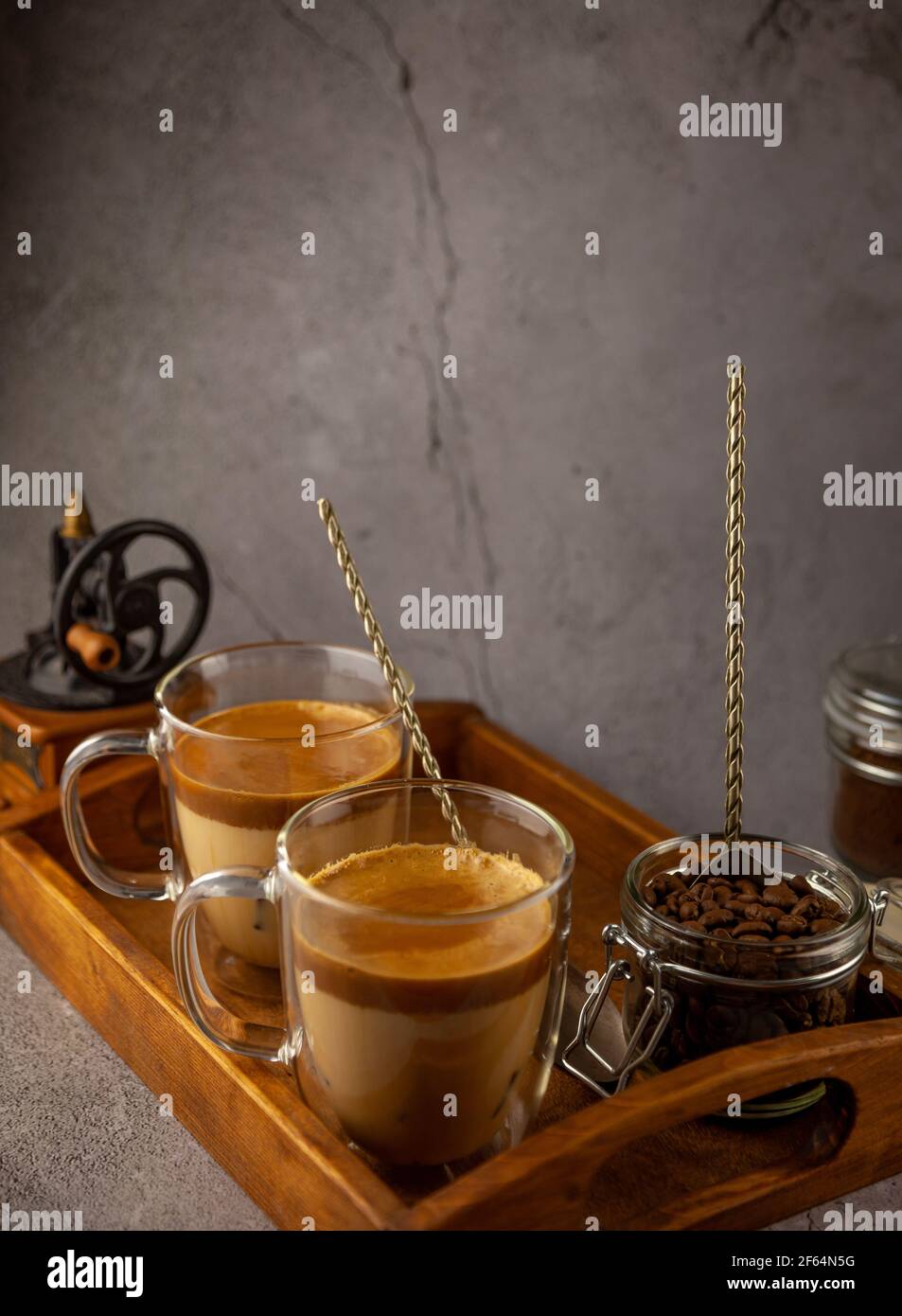 Dalgona Coffee - la bevanda coreana di caffè su sfondo di legno. Caffè istantaneo o espresso in polvere con zucchero e acqua calda. Algone montato ghiacciato Foto Stock